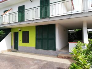 a building with green shutters and a balcony at residenza acquamarina fronte mare in Paestum