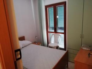 a bedroom with a bed and a chair and a window at residenza acquamarina fronte mare in Paestum