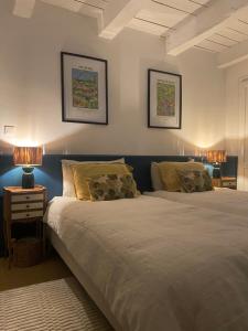 a bedroom with two beds and two lamps on the wall at Le Coucou Montcuq in Montcuq