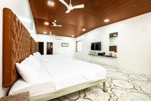a bedroom with a large bed with a wooden headboard at Coco Bliss By Mauli Stays in Manor