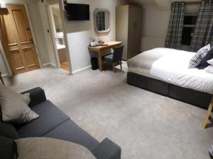 ein Hotelzimmer mit einem Bett und einem Sofa in der Unterkunft The Fenwick Steak & Seafood Pub in Lancaster