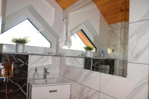 un bagno con lavandino e finestra di Domek na Wielkiej Górze a Waksmund