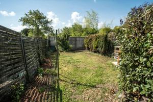 a fence in the yard of a house at Maison de ville NLR - 6 lits simples - BBQ - Proche Gare - grand Parking in Nogent-le-Rotrou