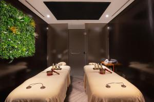 two beds with glasses on them in a room at The First Collection Dubai Marina in Dubai