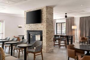 阿灵顿Homewood Suites by Hilton Boston Cambridge-Arlington, MA的大堂设有壁炉和桌椅。