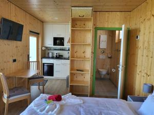 a bedroom with a bed and a kitchen with a table at mein kleinDOMIZIL Mittenaar in Mittenaar