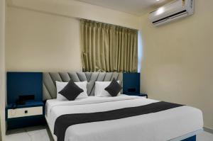 a bedroom with a large white bed with a window at Palm Suites Baner- indian nationals only in Pune +28 photos