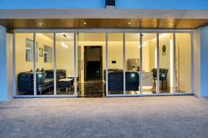 a room with glass windows and a room with furniture at Palm Suites Baner- indian nationals only in Pune