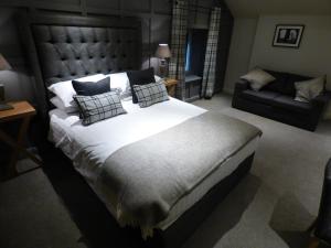 1 dormitorio con 1 cama grande y 1 sofá en The Fenwick Steak & Seafood Pub, en Lancaster