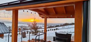 Domek na Wielkiej Górze في Waksmund: منظر من شرفة نزل للتزلج مع غروب الشمس