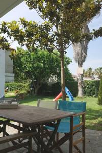 a wooden table with two chairs and a tree at Filippos house in Nea Fokaia in Nea Fokea