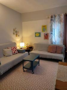 a living room with two couches and a table at Filippos house in Nea Fokaia in Nea Fokea