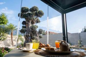 un tavolo con del cibo e un albero sullo sfondo di Divina Charme a Mascalucia