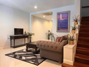 a living room with a couch and a piano at 3BR Sukhumvit Townhouse, close to Emsphere and BTS MRT in Bangkok