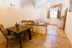 uma sala de estar com uma mesa e cadeiras e um sofá em Apartments U Krále Brabantského em Praga