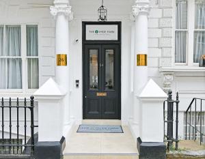 a black door on a white house with columns at The J Hyde Park Hotel in London