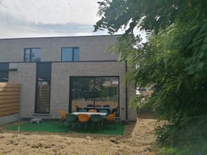 ein Haus mit einem Tisch und Stühlen davor in der Unterkunft Dunehill in Balen