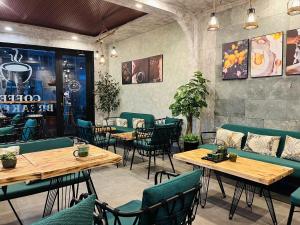 ein Restaurant mit Tischen und Stühlen in einem Raum in der Unterkunft Chez Mimosa Corner - New address 90 Đề Thám in Ho-Chi-Minh-Stadt