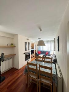 a living room with a table and chairs and a couch at Margas Golf Apartment in Sabiñánigo