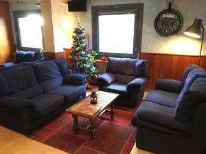 a living room with blue couches and a christmas tree at Hotel Casado in Pas de la Casa