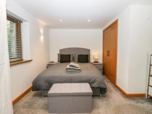 a bedroom with a bed and a bench in it at Low Fold Cottage in Penrith