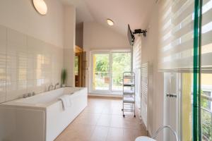 a bathroom with a tub and a window and a ladder at Ferienhaus Rübezahl am Müggelsee in Berlin +53 photos