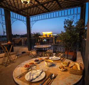 a table with plates of food on a balcony at Riad Layla in Fez