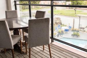 a dining room table with chairs and a view of a pool at Mauya Guesthouse in Kuilsrivier
