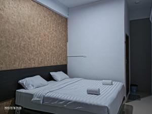 a bed with two pillows on it in a room at Syaheer Inn in Takengon