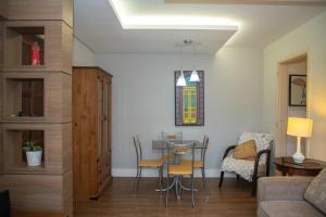 a living room with a table and chairs at Entre Parque Moinhos e Country Club POA ZG6320 in Porto Alegre