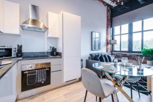 a kitchen and living room with a table and chairs at Meadow Mill Apartments by Staycay in Heaton Norris +12 photos