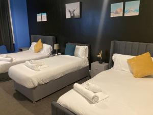 a room with two beds with towels on them at North Coast Hotel in Blackpool