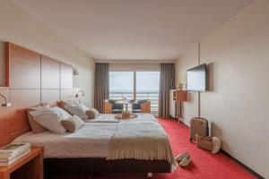 een hotelkamer met een groot bed en een raam bij Hotel Riant-Séjour by WP Hotels in Blankenberge