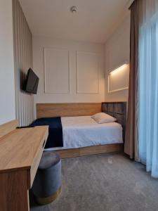 a small room with a bed and a desk and a desk at IVY Healthy Stay in Konstancin-Jeziorna