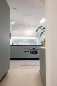 a kitchen with white cabinets and a stove at Trubarjeva City apartments in Ljubljana