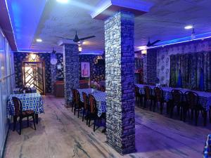 a dining room with tables and chairs and a brick wall at HOTEL SUDAKSHINA by ROH in Silchar
