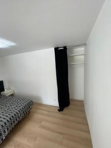 a bedroom with a bed and a white wall at Paris chez jade in Thiais