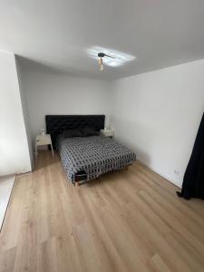 a bedroom with a bed and a wooden floor at Paris chez jade in Thiais