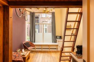 a living room with a window and a ladder at The Disco Duck A - city centre Zwolle in Zwolle