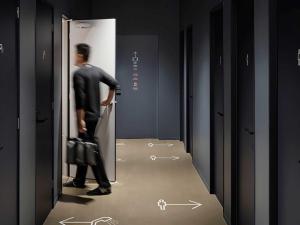 a man in a suit walking into a locker room at 9h nine hours Shinagawa station for men in Tokyo +21 photos