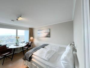 a bedroom with a bed and a table and a window at Ferienwohnung Lönkiker in Westerland (Sylt)
