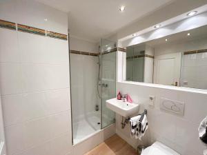 a bathroom with a shower toilet and a sink at Ferienwohnung Lönkiker in Westerland (Sylt) +4 photos