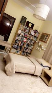a couch in a living room with a book shelf at فيلا بجوار المطاعم والكافيهات in Khumrah