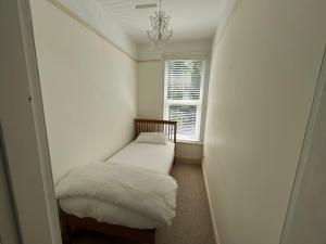 a small room with a bed and a window at Entire Victorian House 3 bedrooms in Mannamead