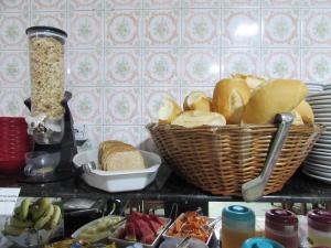 a bunch of bread in a basket on a counter at New Comercial Palace Hotel in São Paulo