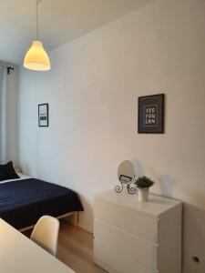 ein Schlafzimmer mit einem Bett und einer Kommode in der Unterkunft Mieszkanie w centrum Gdyni SW 135L in Wzgórze Nowotki