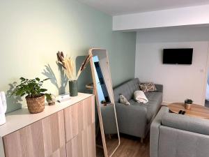 ein Wohnzimmer mit einer Couch und einem Spiegel in der Unterkunft Appart cosy, calme proche centre in Caen + 5 Fotos