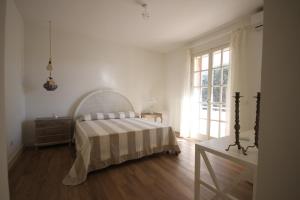 een witte slaapkamer met een bed en een raam bij Villa Teresa Maria in Porto Cesareo