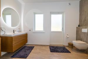 a bathroom with a sink and a toilet and a mirror at Villa in Akureyri with a hot tub and scenic view in Akureyri