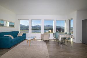a living room with a blue couch and a table at Villa in Akureyri with a hot tub and scenic view in Akureyri